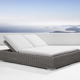 Montauk Outdoor Double Chaise against a sea view.
