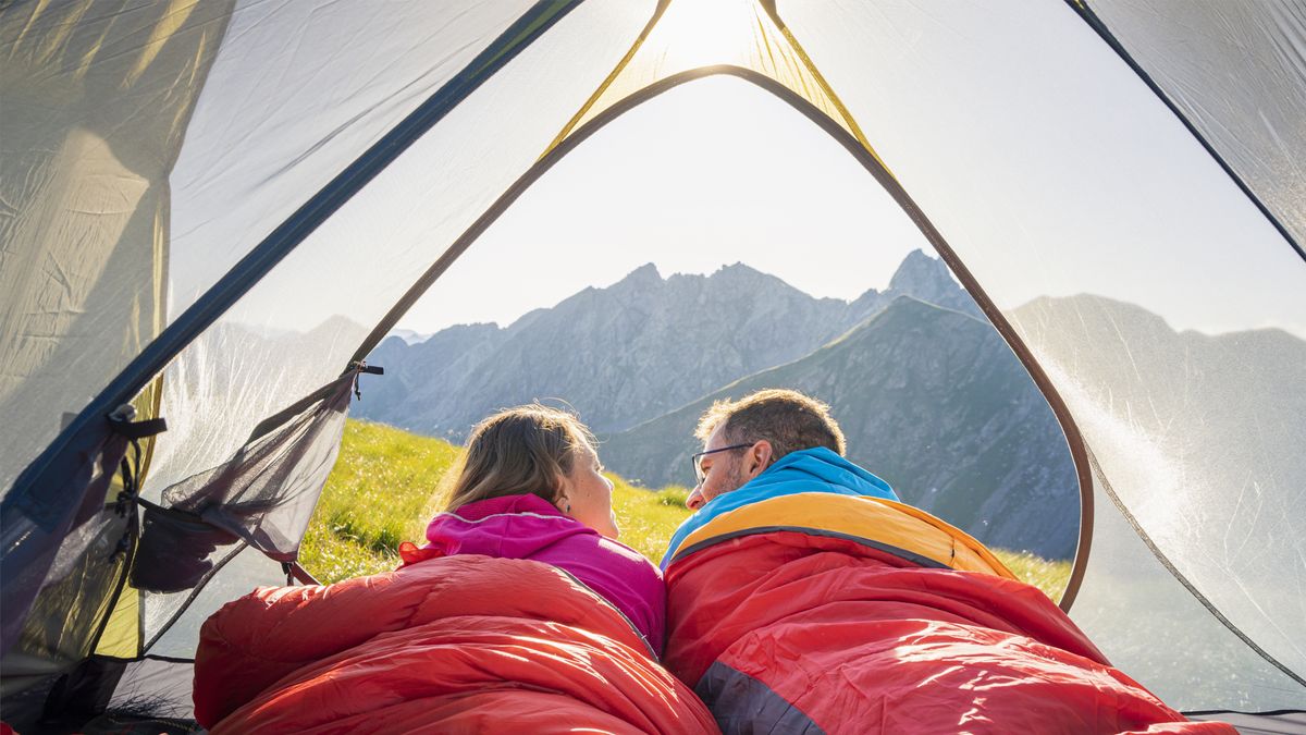 Couple lying down in a tent on the mountains, Italy.