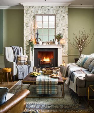 Fall mantel ideas with blue and white vase matching blue and white tartan blankets on grey sofas