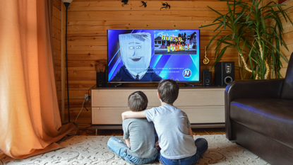 Best TV under £500: Image depicts two children sat on floor in front of TV