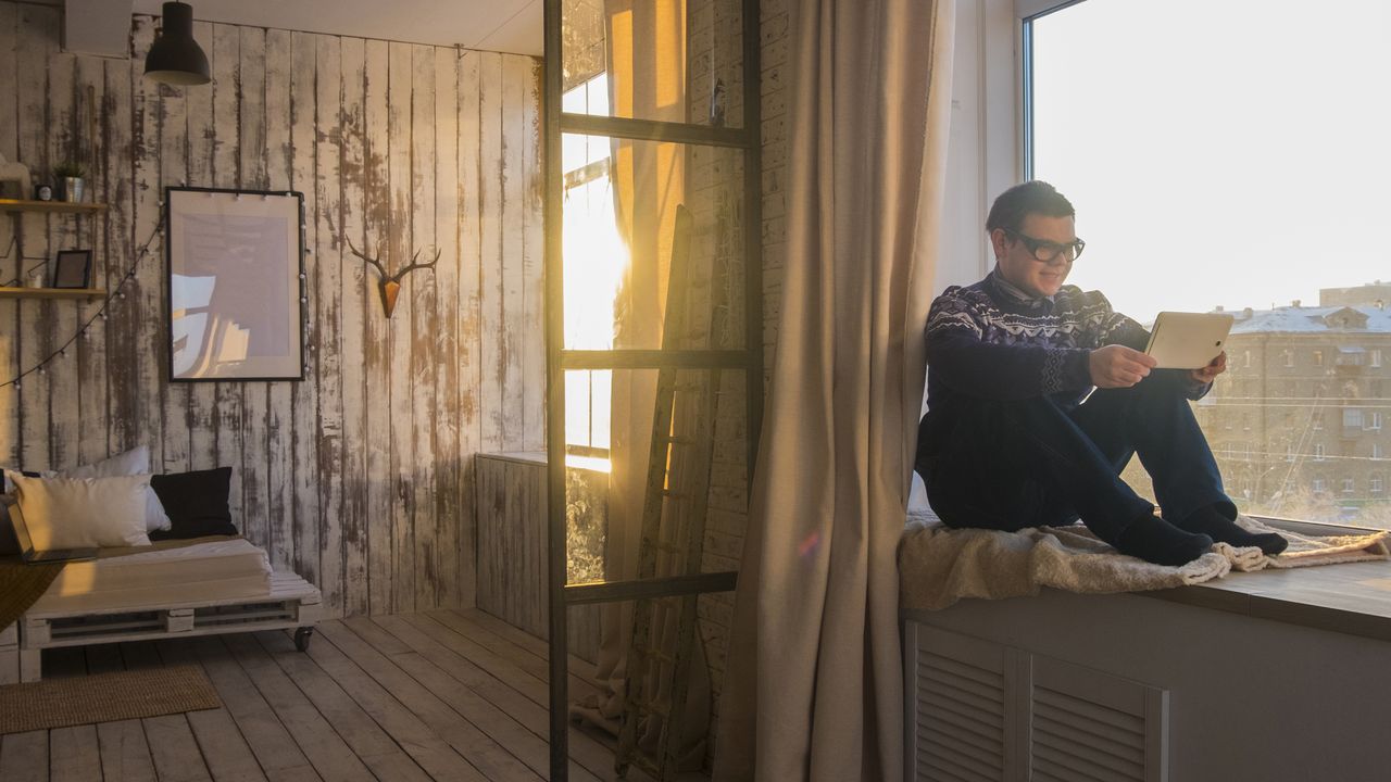 Man sitting near a sunlit window in winter