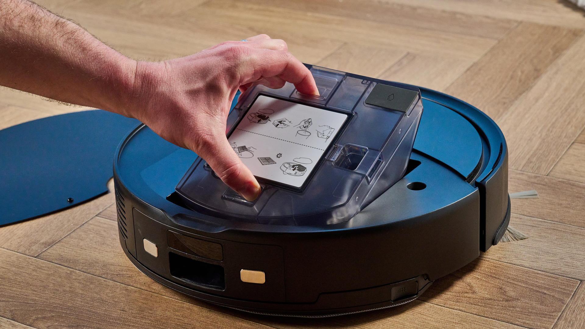 Roborock Q10 S5+ photographed on a wooden floor in front of a blue background