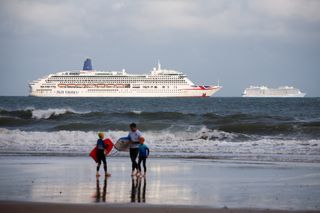 Cruise ships, including P&O liner Aurora and the Royal Caribbean-owned Anthem of the Seas, wait out the coronavirus pandemic at anchor in the English Channel off the beach resort coast of Bournemouth, England, on August 22, 2020.