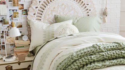 White bed with green knit blanket
