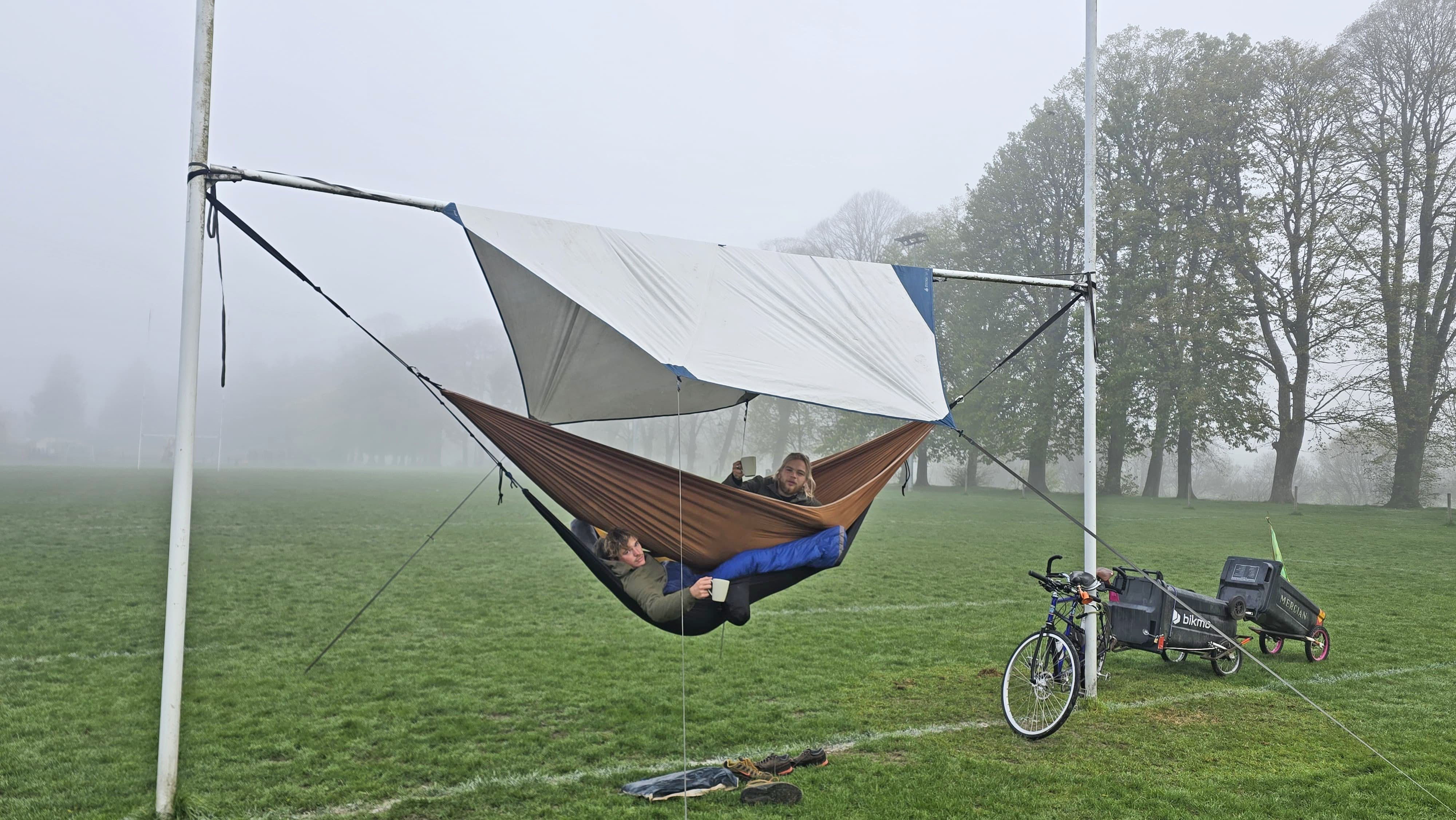 Jamie Hargreaves and Alfie Cookson sleeping in hammocks between rugby posts