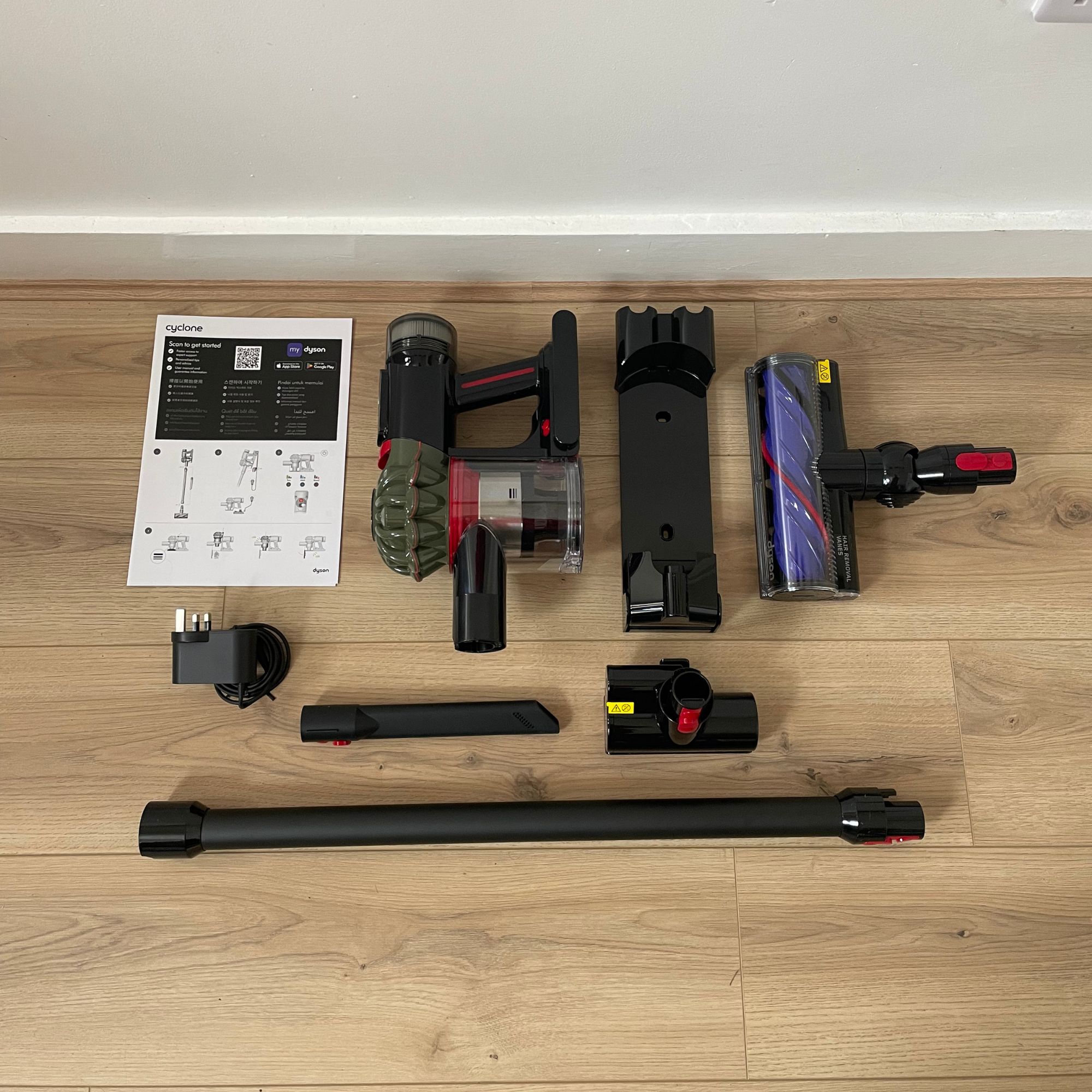 Dyson V8 Cyclone components laid out on wood-effect flooring