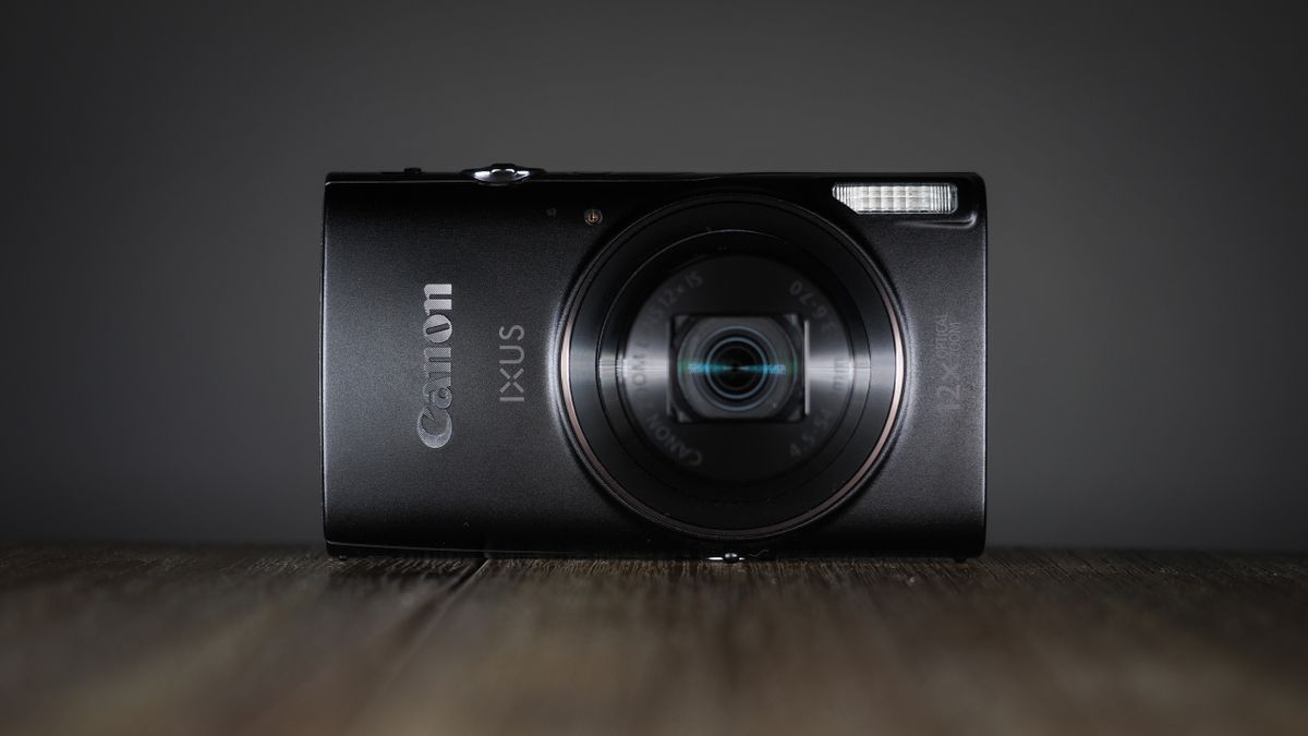 Canon Ixus 285 HS A on a wooden surface against a dark background