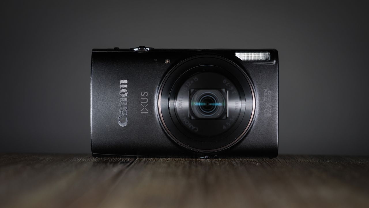 Canon Ixus 285 HS A on a wooden surface against a dark background