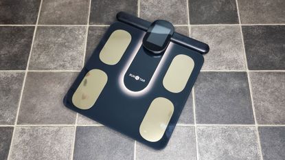 The Runstar 8E SmartScan Pro body fat scale on a bathroom floor