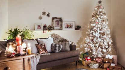 a small apartment with a couch and christmas decor and a christmas tree
