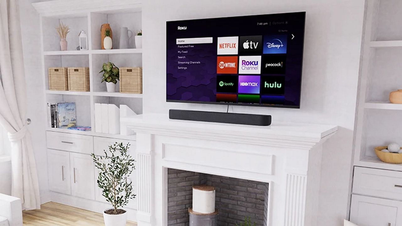 Roku Streambar Pro on mantelpiece below TV showing Roku interface