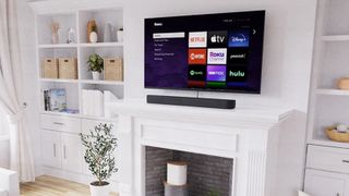 Roku Streambar Pro on mantelpiece below TV showing Roku interface