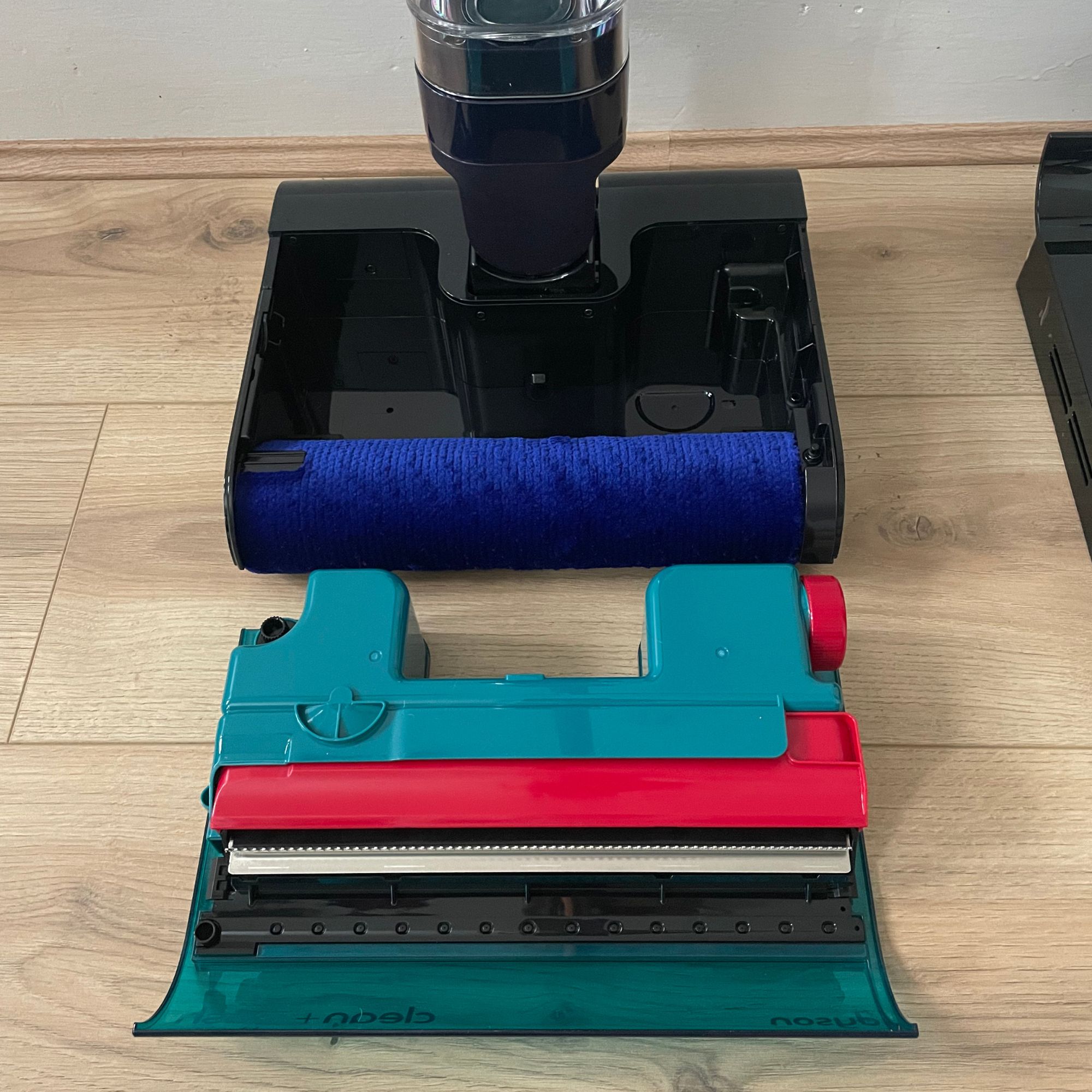 Dyson Clean+Wash Hygiene floorhead separated into parts on wood-effect flooring