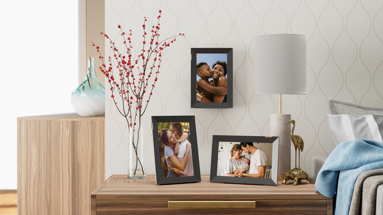 A collection of three Nixplay 10.1-inch Touchscreen Digital Picture Frames on a sideboard