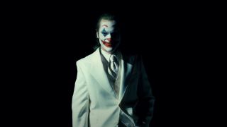 Joaquin Phoenix in Joker clown makeup wearing white suit