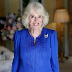 Queen Camilla wearing a blue dress and smiling