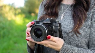 author holding the OM-1 Mark II in the hand