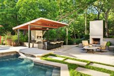A backyard with outdoor kitchen and fireplace