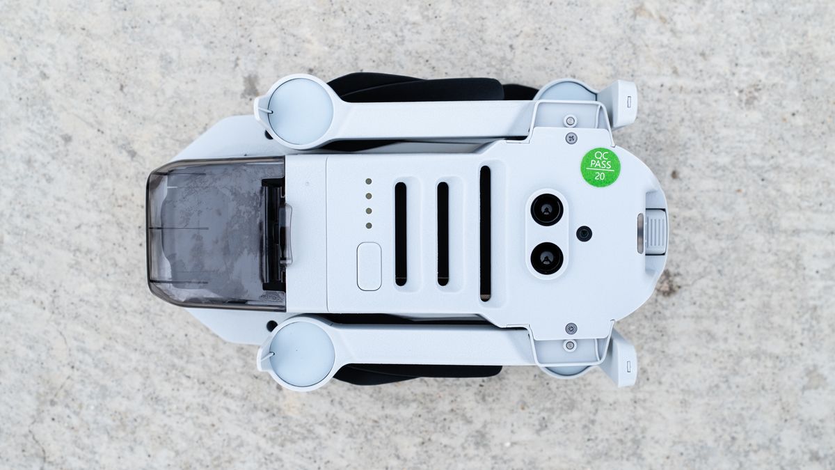 the underside of a white, folded drone, with lenses and slits on the body.