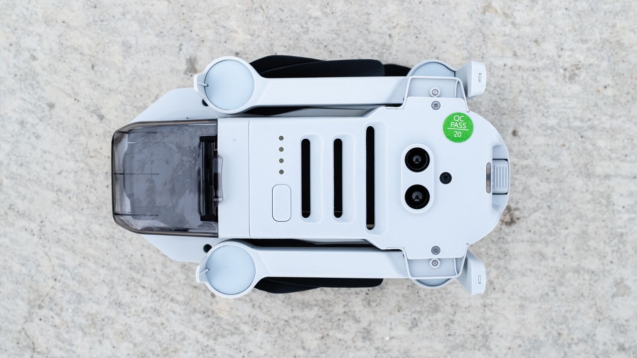 the underside of a white, folded drone, with lenses and slits on the body.