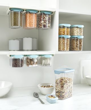 Joseph Joseph cupboardstore containers filled with dried pulses and cereals in white cupboard