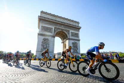 the peloton passes below the Arc de Triomphe in Paris on the final stage of the 2022 Tour de France