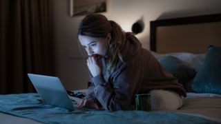 Kaitlyn Dever as Belle Gibson, before she was famous in a tracksuit and staring at a computer on her bed.