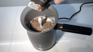 Chocolate flakes being added to milk in the Hotel Chocolat Velvetiser