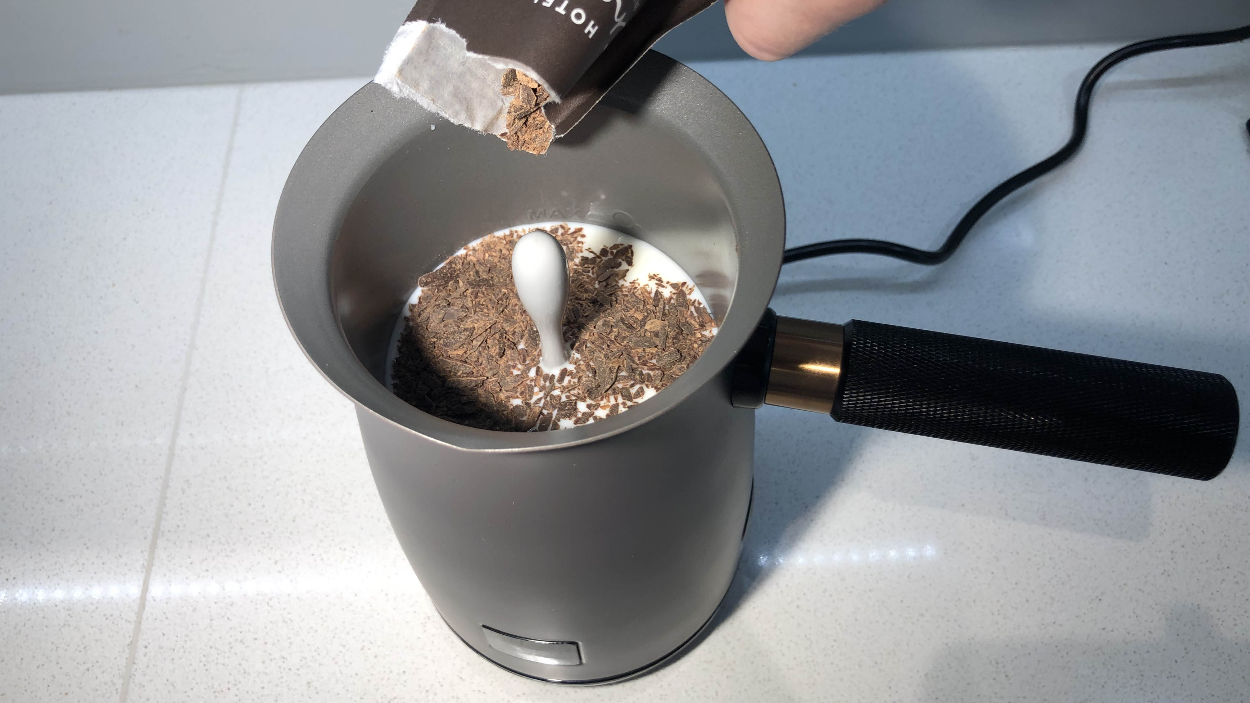 Chocolate flakes being added to milk in the Hotel Chocolat Velvetiser