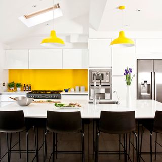 whitew kitchen with yellow wall and dining table