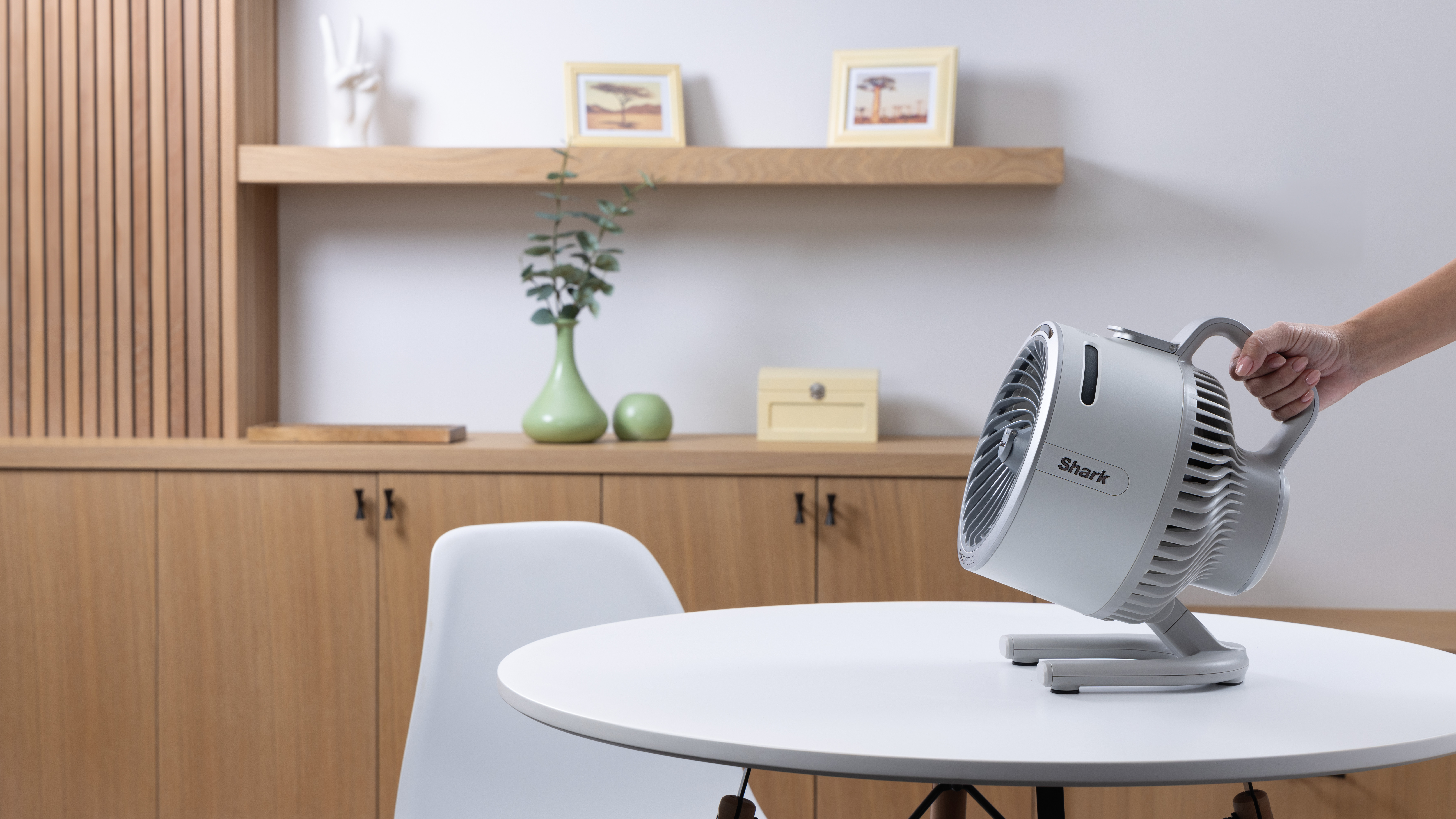 woman's hand holding shark flexbreeze hydrogo fan in apartment living room