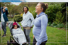 A group of pregnant women dressed to exercise in the park laughing next to a child in a buggy