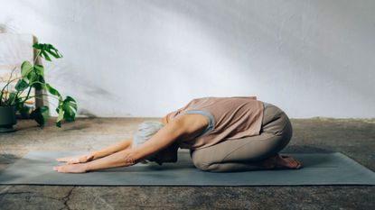 A woman performing the child's pose as part of a yoga session