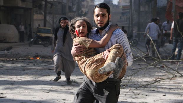 A man carries a wounded girl following a &amp;#039;barrel bomb&amp;#039; attack in Aleppo