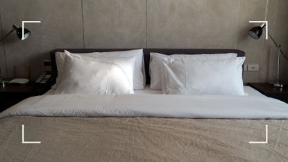 Grey bedroom with grey and white bed linen with a white silk pillowcases to illustrate silk pillowcase benefits at home