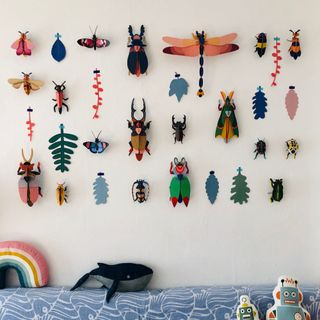 A kids bedroom wall decorated with paper insects