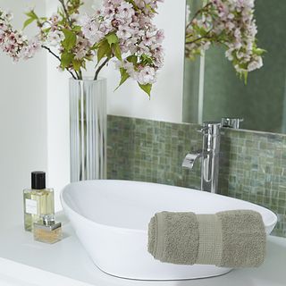 bathroom with white wash basin and flower in glass vase