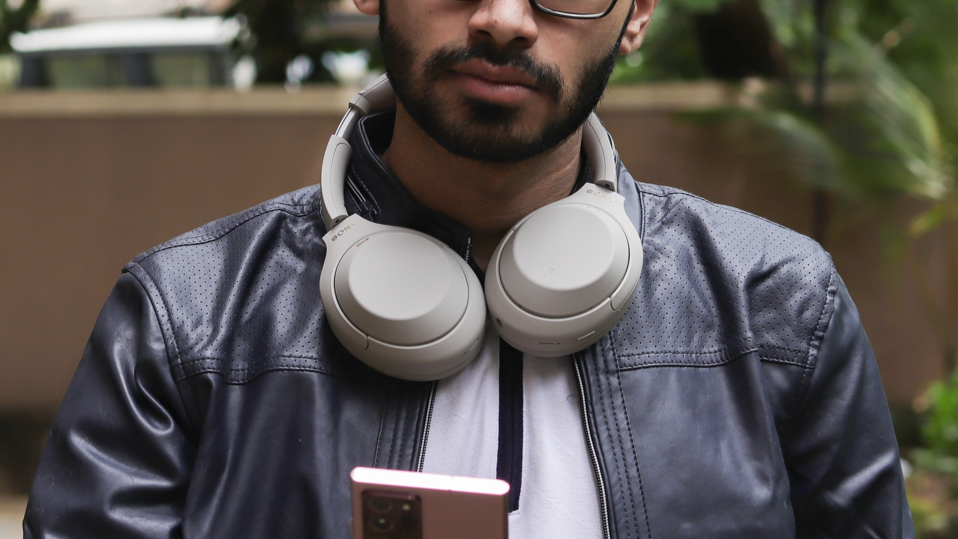 Man wearing Sony WH-1000XM4 headphones around his neck