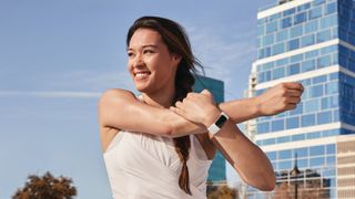 Woman stretching wearing Fitbit fitness tracker