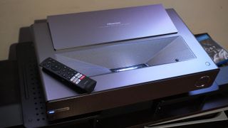 Hisense PX-1 Pro UST Projector with remote control on top surface