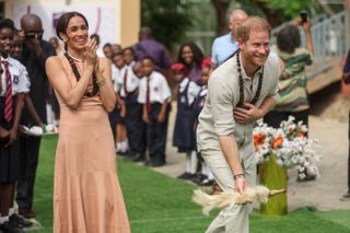Duke of Sussex, and Britain's Meghan (L), Duchess of Sussex, take part in activities as they arrive at the Lightway Academy in Abuja on May 10, 2024 as they visit Nigeria as part of celebrations of Invictus Games anniversary.