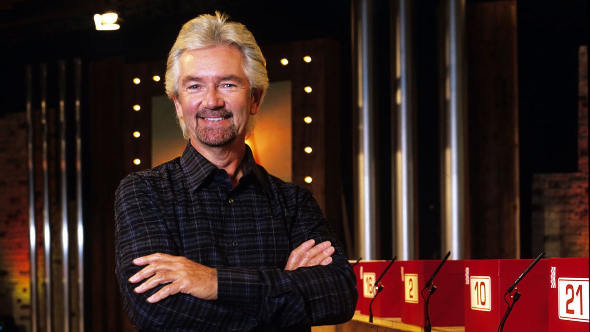 Noel Edmonds stood on the set of Deal Or No Deal next to one set of red boxes