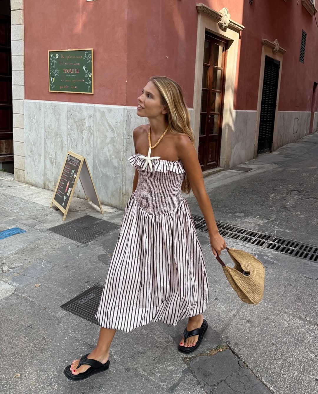Rita Montezuma wears striped dress with black flip flops