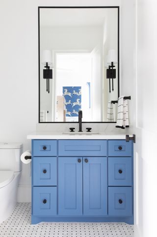 blue vanity in a monochrome bathroom