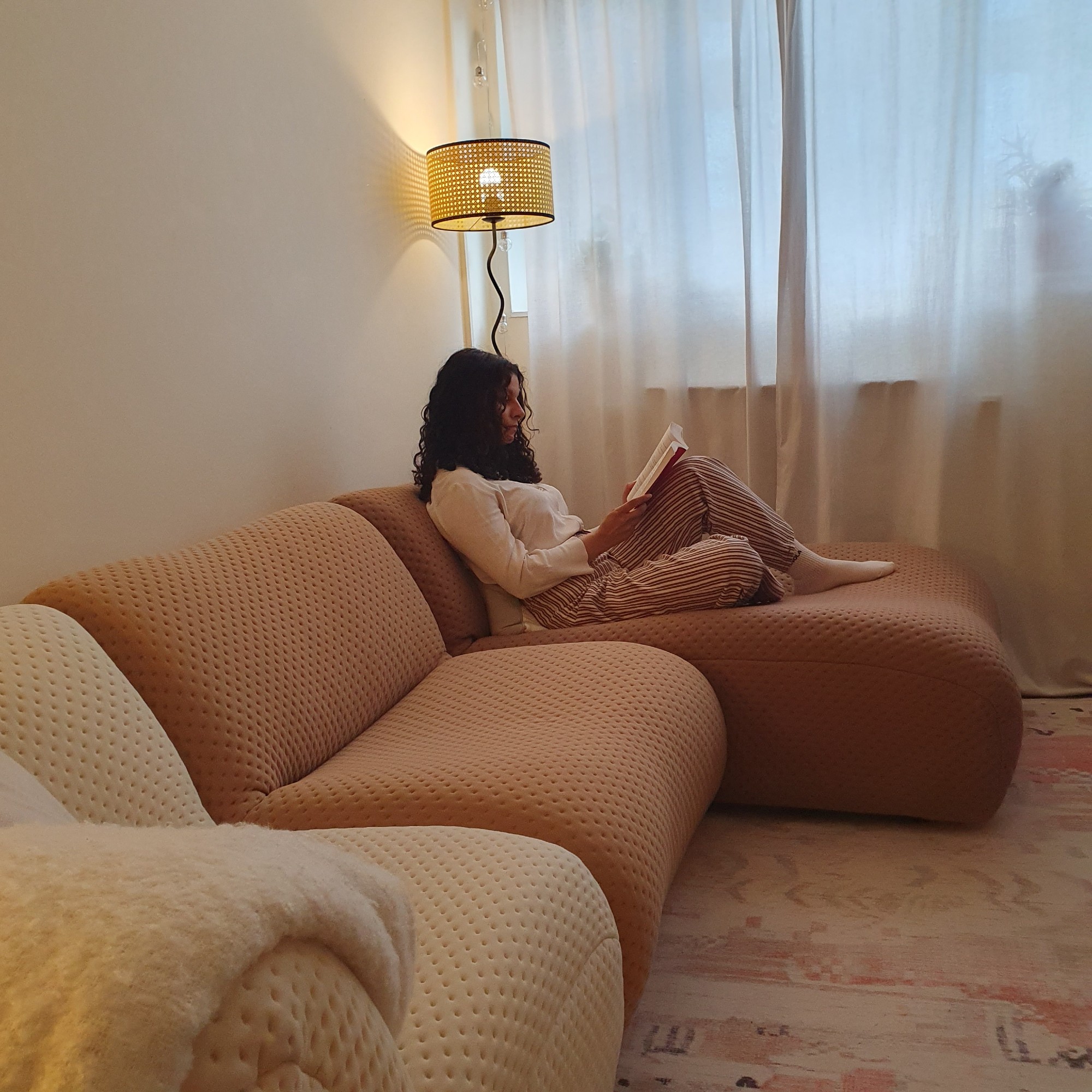 Sara sitting on her modular King Living 1977 sofa in her living room