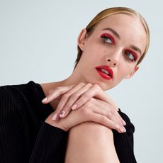 Model wearing a red lipstick on both her lips and eyes