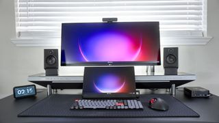 The Kamrui E3B on the right side of a multi-monitor desk setup