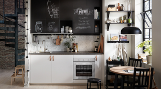 A small kitchen with chalkboard, white cabinets and oven in a modern open plan living space by IKEA