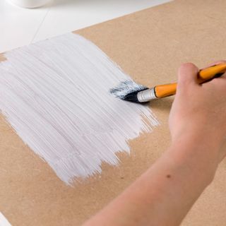 paint brush with fibreboard and white paint