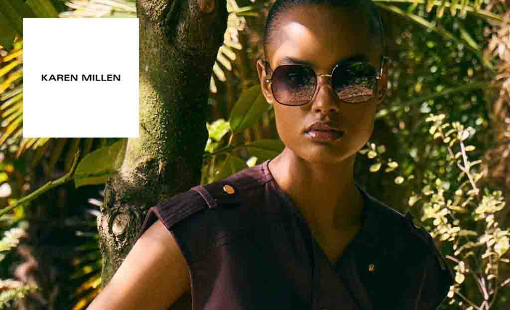 Karen Miller logo placed over a model posing with sunglasses in a forest 